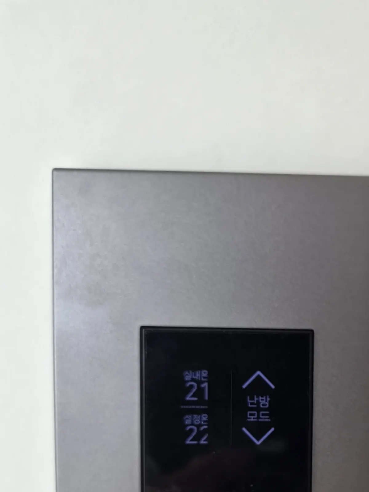 마그네슘 그레이 플레이트 표면과 모서리, 아래쪽에 온도조절기 화면이 보이는 근접 사진